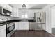Beautiful kitchen boasting stainless steel appliances, ample counter space, and sleek white cabinetry at 7977 Durango St, Denver, CO 80221