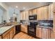 Kitchen featuring wood cabinets, granite counters, stainless steel appliances and a view into the living room at 7033 S Versailles St, Aurora, CO 80016