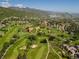 Stunning aerial view of green golf course surrounded by mountain ranges and luxury homes at 6268 Dakota Ridge Dr, Littleton, CO 80125