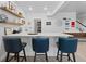 Home bar with sleek white countertops, floating shelves, and seating for three at 6268 Dakota Ridge Dr, Littleton, CO 80125