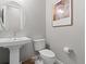 Modern bathroom with a pedestal sink, oval mirror, and neutral color scheme at 6268 Dakota Ridge Dr, Littleton, CO 80125