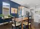 Dining area with dark wood floors, a wood table, blue accent wall, and stylish pendant lighting at 6268 Dakota Ridge Dr, Littleton, CO 80125