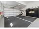 Spacious two-car garage featuring clean epoxy flooring, storage cabinets and organized tool rack at 6268 Dakota Ridge Dr, Littleton, CO 80125