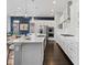 Modern kitchen featuring white cabinets, a large island, stainless steel appliances, and dark hardwood floors at 6268 Dakota Ridge Dr, Littleton, CO 80125