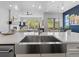Bright, open kitchen featuring a large island, stainless steel sink, and views to living area and beyond at 6268 Dakota Ridge Dr, Littleton, CO 80125