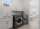 Laundry room with modern washer and dryer, cabinets, sink, and bright lighting at 6268 Dakota Ridge Dr, Littleton, CO 80125