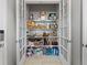 Walk-in pantry with well-organized shelving behind glass paneled doors and recessed lights at 6268 Dakota Ridge Dr, Littleton, CO 80125