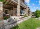 Inviting covered patio area with stone pillars and access to a well-maintained lawn and upper balcony at 6268 Dakota Ridge Dr, Littleton, CO 80125