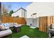 Cozy backyard featuring a modern outdoor seating area, turf, privacy fence, and a convenient gas grill at 1250 W Osceola St # 2, Denver, CO 80204