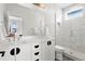 Modern bathroom with double vanity, glass shower, and gray tiled floor at 1250 W Osceola St # 2, Denver, CO 80204