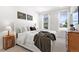 Bright bedroom with white linens, two windows, and light wood floors at 1250 W Osceola St # 2, Denver, CO 80204
