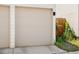 Two-car garage exterior featuring a beige door, concrete driveway, and some greenery surrounding at 1250 W Osceola St # 2, Denver, CO 80204