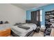 Bedroom featuring bright blue accent wall, window, and dark curtains at 2246 S Ensenada St, Aurora, CO 80013