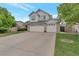Traditional home with a large driveway and three car garage, complemented by a well-manicured lawn at 2246 S Ensenada St, Aurora, CO 80013