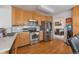 Well-lit kitchen with wooden cabinets and stainless steel appliances, adjacent to a dining area at 2246 S Ensenada St, Aurora, CO 80013