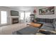 Cozy living room featuring a fireplace, a plush gray sectional, and ample natural light at 2246 S Ensenada St, Aurora, CO 80013