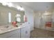 Bright bathroom features double sinks, large mirrors, and a glass-enclosed shower for a spa-like experience at 4732 Windmill Dr, Brighton, CO 80601
