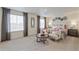 Spacious bedroom featuring large windows, inviting chairs, and stylish decor for ultimate relaxation at 4732 Windmill Dr, Brighton, CO 80601