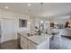 Kitchen island featuring stainless steel dishwasher and granite countertop with adjacent dining and living area at 4732 Windmill Dr, Brighton, CO 80601