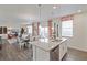 Kitchen island featuring stainless steel dishwasher and granite countertop with adjacent dining and living area at 4732 Windmill Dr, Brighton, CO 80601