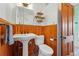 Well-lit bathroom with a pedestal sink, wood paneling, and updated fixtures at 91 S Sherman St, Denver, CO 80209