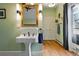Bright bathroom with pedestal sink, wood floors, and accent lighting fixtures at 91 S Sherman St, Denver, CO 80209