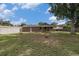 Large backyard view with a brick house and covered patio under a blue sky with scattered clouds at 760 Dean Dr, Northglenn, CO 80233