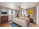 Cozy bedroom with a ceiling fan, two windows, hardwood floors, and neutral tones at 760 Dean Dr, Northglenn, CO 80233