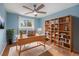 Bright home office with a built-in bookcase, wooden floors, and a large window offering a view of the yard at 760 Dean Dr, Northglenn, CO 80233