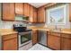 A traditional kitchen with wooden cabinets, stainless steel appliances, and ample counter space by the window at 760 Dean Dr, Northglenn, CO 80233