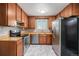 Functional kitchen with stainless steel appliances, wood cabinets, and a window over the sink at 760 Dean Dr, Northglenn, CO 80233