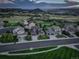 Expansive aerial view of suburban neighborhood at dusk, showcasing manicured lawns and mountain views at 1176 Dales Pony Dr, Castle Rock, CO 80104