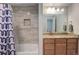 Well-lit bathroom featuring a granite countertop vanity, bath and shower with tiled walls, and unique shower curtain at 1176 Dales Pony Dr, Castle Rock, CO 80104
