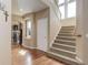 Inviting entryway with hardwood floors, staircase, and a view of the living room with a fireplace at 1176 Dales Pony Dr, Castle Rock, CO 80104
