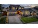 Charming two-story home with stone accents, three-car garage, and landscaped front yard at dusk at 1176 Dales Pony Dr, Castle Rock, CO 80104