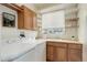 Functional laundry room featuring cabinets, open shelving, a sink, and a front load washer and dryer at 1176 Dales Pony Dr, Castle Rock, CO 80104