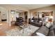 Bright living room showcasing leather sofas, a decorative rug, and open access to the kitchen and dining areas at 1176 Dales Pony Dr, Castle Rock, CO 80104
