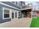 Backyard patio with white french doors to interior, decorative string lights, outdoor seating and stairs to deck at 1176 Dales Pony Dr, Castle Rock, CO 80104