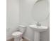 Powder room featuring a pedestal sink, round mirror, and modern fixtures at 6562 Arbor Blvd # 4, Thornton, CO 80602