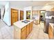Kitchen featuring an island cooktop, stainless steel refrigerator, light wood cabinets, and access to a pantry and other rooms at 412 E 131St Ave, Thornton, CO 80241