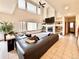 Sunlit living room featuring tall ceilings, a fireplace, and large sectional sofa at 412 E 131St Ave, Thornton, CO 80241