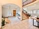 Open-concept living area featuring a staircase, a play area, and neutral tile flooring throughout at 412 E 131St Ave, Thornton, CO 80241