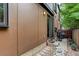 Exterior view of backyard and patio area with a grill, complemented by modern siding and stone landscaping at 2138 N Glenarm Pl, Denver, CO 80205