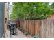 Charming backyard with a wooden fence, mature trees, and a small patio area, providing a private outdoor space at 2138 N Glenarm Pl, Denver, CO 80205