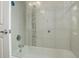 Modern bathtub with tile surround and glass door in this well-lit bathroom at 2138 N Glenarm Pl, Denver, CO 80205