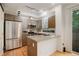 Modern kitchen with stainless steel appliances and an island with light countertops and seating at 2138 N Glenarm Pl, Denver, CO 80205