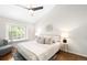 Sunlit bedroom featuring large window, ceiling fan, hardwood floors, and light colored bedding at 7373 E Iowa Ave # 1124, Denver, CO 80231