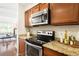 Close up of kitchen with granite counters, stainless steel oven, and wood cabinets at 7373 E Iowa Ave # 1124, Denver, CO 80231