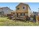 View of back exterior featuring wooden deck, grassy yard, and tan siding at 11302 Tumbleweed Way, Parker, CO 80138