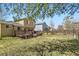 Large, grassy backyard featuring a deck, mature trees, and a wooden fence at 11302 Tumbleweed Way, Parker, CO 80138